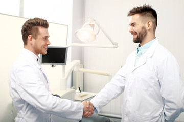 Naklejka na ściany i meble Two male doctors handshaking
