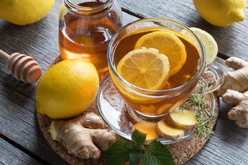 A cup of tea with ginger root, lemon, melissa and honey