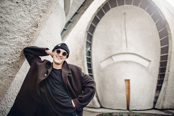 Obraz premium Young man dressed like hipster having fun in retro futuristic architecture