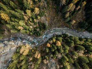 Aerial view of river flowing through forest in alpine valley in Switzerland