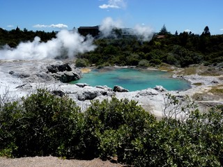 landscape of hot geotermal area with colored water and smoke, New Zealand