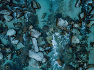 Aerial view of river flowing between rocks, close up