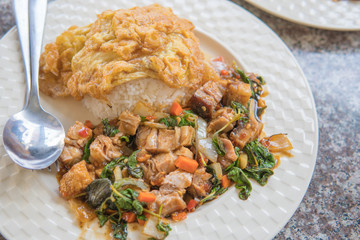 Thai Food - Thai Hot Crispy Pork Basil Rice With Fried Egg on White Dish and Granite Dining Table at Lunch