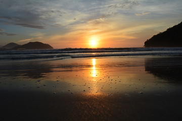Fototapeta na wymiar Sunrise, with reflection in the sea, on the beach Perequê Açu in Ubatuba, Brazil