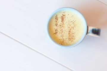 Delicious Golden Latte (Turmeric Latte with Nut Milk, cinnamon, honey, ginger) on white background with copyspace. Closed up