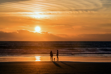 Leute am Strand bei Sonnenuntergang