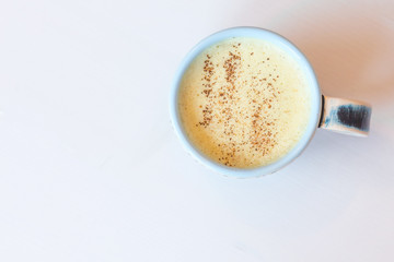 Delicious Golden Latte (Turmeric Latte with Nut Milk, cinnamon, honey, ginger) on white background with copyspace. Closed up