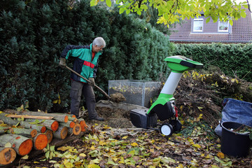 Herbst-Arbeitsplatz im Garten mit Häcksler und Kompost