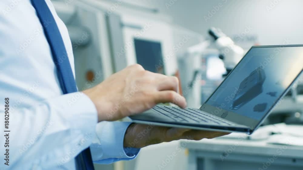 Poster close-up of the engineer holding laptop with cad component model on screen. in the background modern