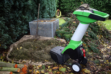 Herbst-Arbeitsplatz im Garten mit Häcksler und Kompost