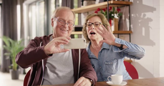 Attractive Senior Couple make a Face Time Call with Smartphone