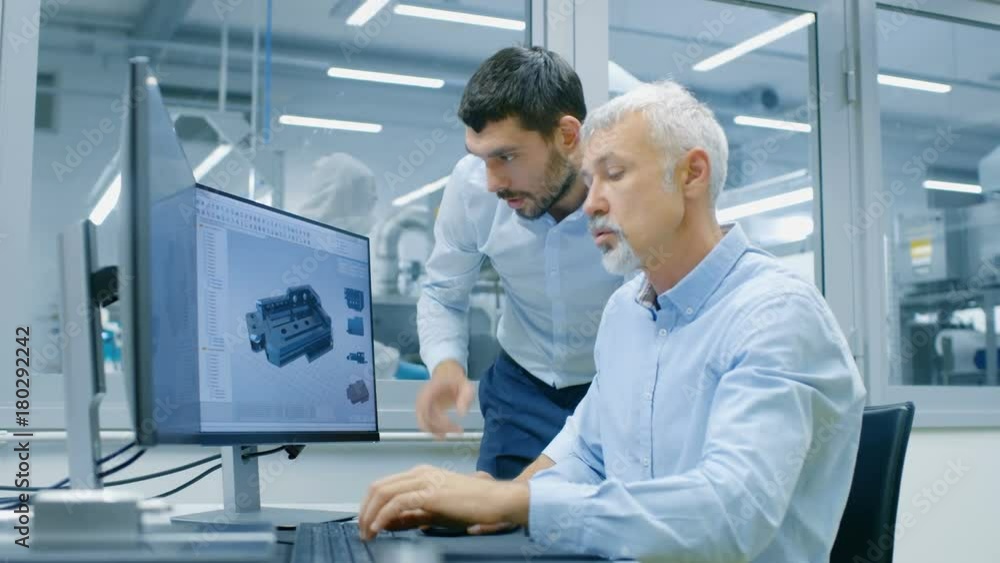 Poster industrial designer has product discussion with senior engineer while working in cad program, design