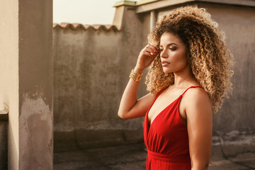 Beautiful and elegant woman portrait standing on rooftop and looking at sunset