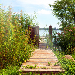 idyllische Landschaft mit Holzsteg und geöffneter Pforte am Schaalsee bei Zarrentin in...