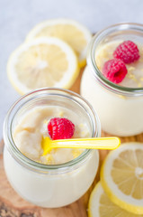 Lemon or vanilla curd in glass jars with raspberry and lemon sli