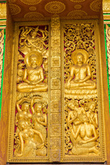 Fototapeta na wymiar The bas-relief on the wall of the temple in Louangphabang, Laos. Close-up. Vertical.
