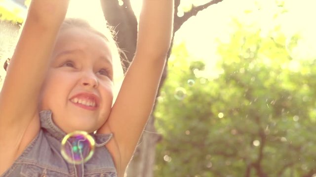 Portrait of a happy smiling little girl having fun outdoor. Slow motion 240 fps. 4K UHD video 3840x2160
