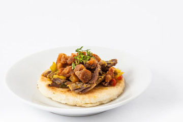 Colombian arepa topped with shredded beef and pork rind