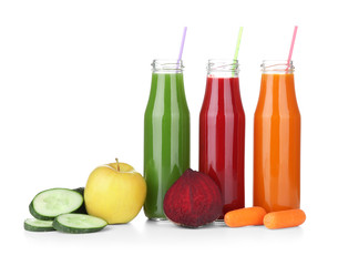 Bottles with various fresh juices and ingredients on white background