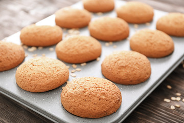 Baking tray with delicious oatmeal cookies on table, closeup