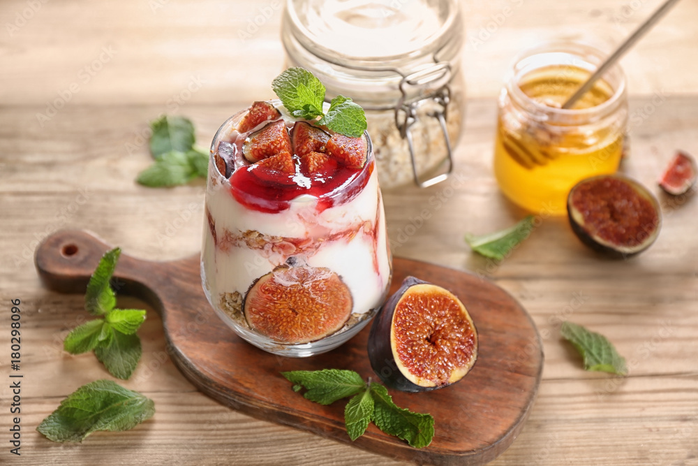 Poster oatmeal dessert with yogurt and fig in glass on table