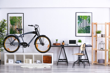 Modern room interior with bicycle and workplace