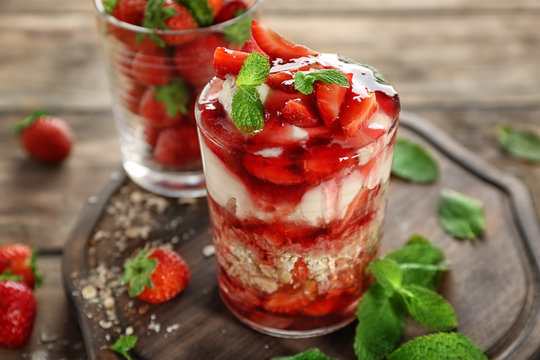Oatmeal dessert with yogurt and strawberry in glass on wooden board