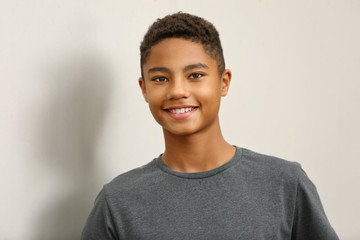 Charming African-American teenager on light background