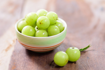 Indian gooseberry fruit in a bowl on wooden background.Healthy and highest vitamin c fruit