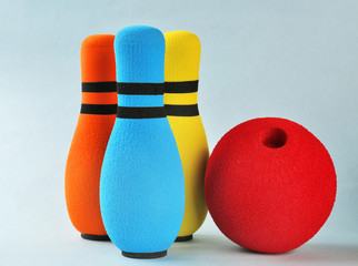 Bright bowling pins and ball on light background