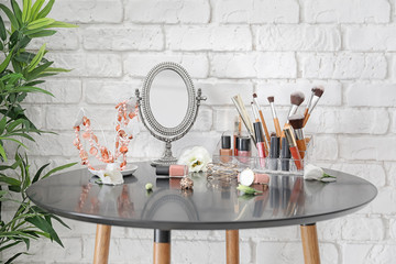Set of decorative cosmetics and beauty accessories on dressing table indoors
