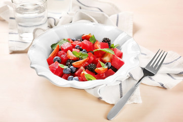 Bowl with delicious watermelon salad on wooden table