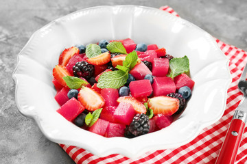 Bowl with yummy watermelon salad on table, closeup