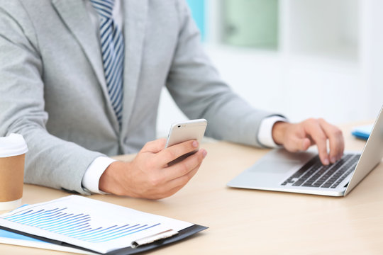 Businessman using mobile phone while working in office