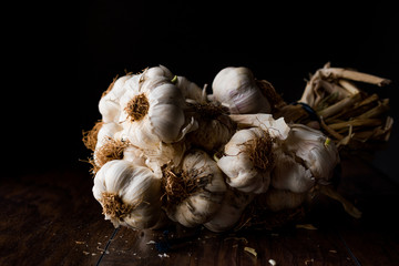Garlic Cloves and Bulb on wooden surface. Dark Moody