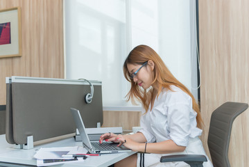 Obraz na płótnie Canvas Thai girl work on the desk,businesswoman in white dress working at the company