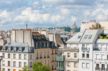 Fototapeta na wymiar Parisian buildings with montmartre and the sacre-coeur in the background, Paris, France
