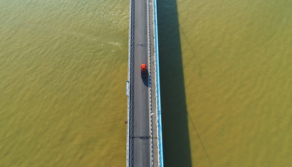 Aerial view. A red car on a bridge.