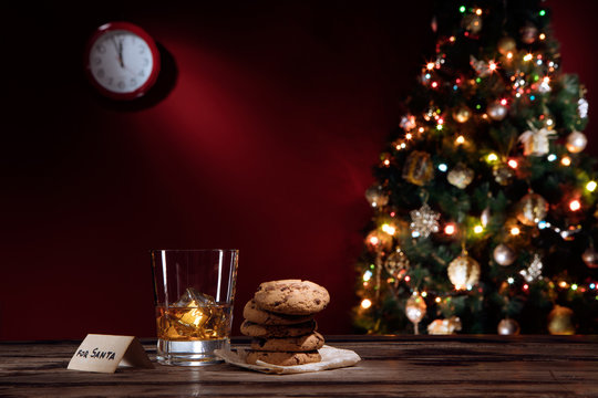 close up view of glass of whiskey with cookies on color back