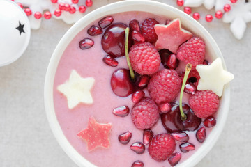 Obraz na płótnie Canvas red pink smoothie bowl with cherry, strawberry, raspberries and pomegranate , christmas fun food