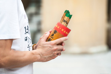 Man holds a box of fortune sticks at Wong Tai Sin temple, Hong Kong