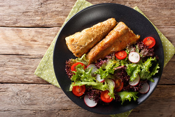 fried in a battered hake and fresh salad close-up. Horizontal top view
