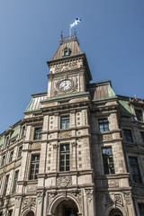 Fototapeta na wymiar Classic clocktower building Quebec City Canada with flag of quebec on a sunny day blue sky