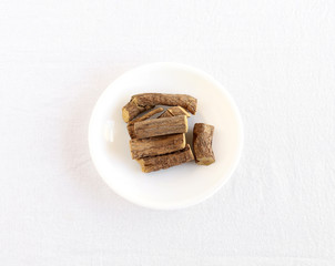 Licorice roots or sweet roots, a sweetener and a potential natural medicine, on a plate.