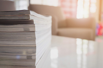 pile of magazines stack on white table in living room