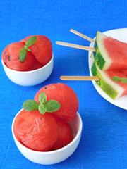 Watermelon pieces formed as balls and as popsicles. Variations of serving