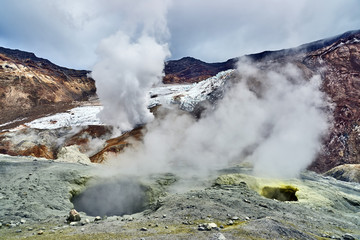 Walking route in the crater of the active volcano Mutnovsky on the Kamchatka Peninsula. Fumarolic fields on thermal areas inside the crater