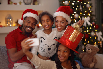 Christmas lovely afro American family making selfie.