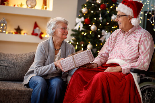 Senior couple at Christmas sharing Christmas gifts.