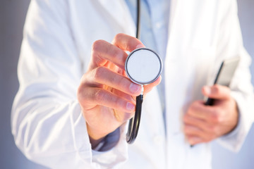 Doctor using stethoscope on a color background